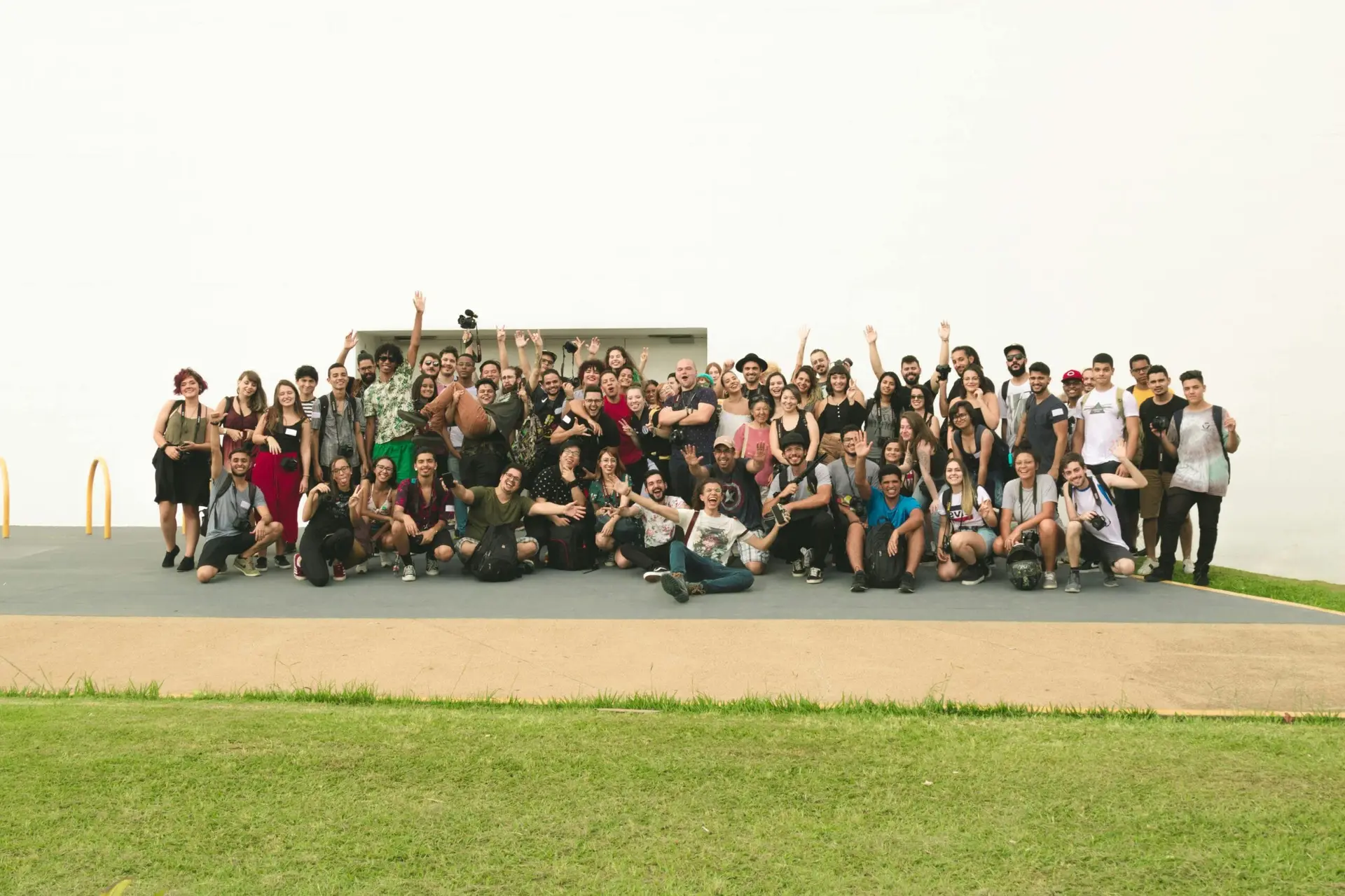 A joyful group of diverse friends celebrating outdoors on a sunny day.